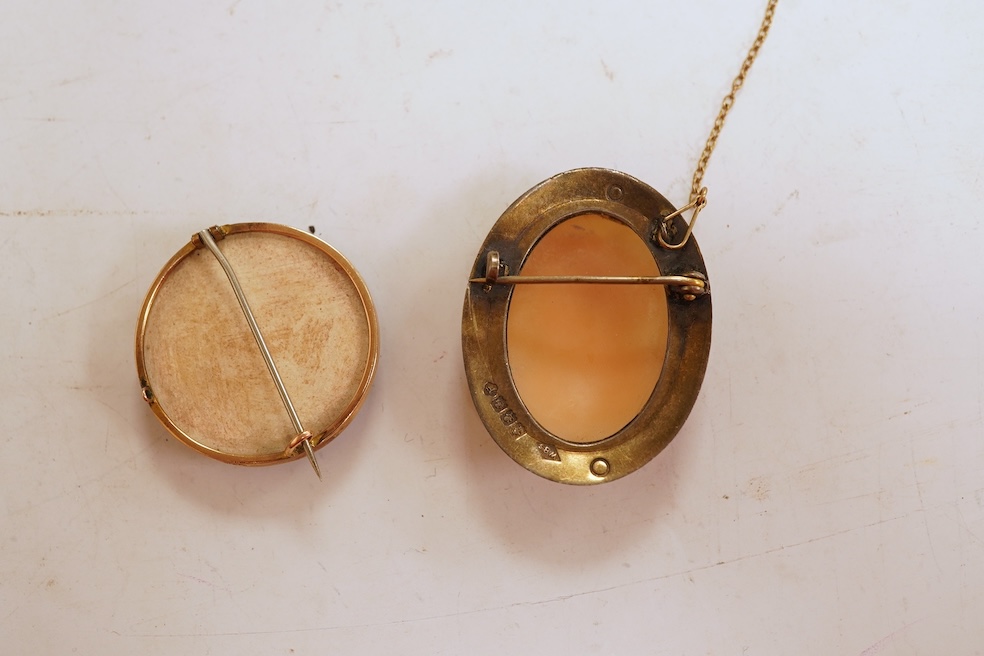 A Satsuma brooch, set with a circular Satsuma plaque depicting an oiran with gilded hair ornaments, mounted in 9ct gold, 3.3cm diameter, British hallmarks; together with an oval shell cameo brooch depicting a classical w